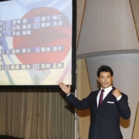 Samurai Japan manager Atsunori Inaba poses in front of a screen displaying the Japan roster for the 2020 Tokyo Olympics | KYODO