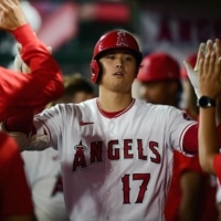 Angels designated hitter Shohei Ohtani celebrates with his teammates after hitting a solo home run against the Astros on Tuesday in Anaheim, California. | USA TODAY / VIA REUTERS