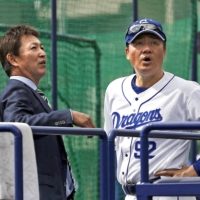 Kazuyoshi Tatsunami (left) speaks with Dragons manager Tsuyoshi Yoda during spring camp in February 2020. On Friday, the the Dragons announced Tatsunami will succeed Yoda as the team manager. | KYODO