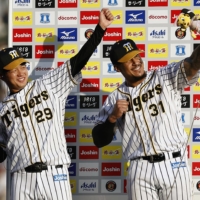 Hanshin's Haruto Takahashi (left) and Jefry Marte celebrate after Saturday's win over the Dragons at Koshien Stadium in Nishinomiya, Hyogo Prefecture. | KYODO