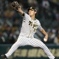 Hanshin's Masashi Ito pitches against the Carp on Monday at Koshien Stadium. | KYODO