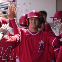 Shohei Ohtani celebrates in the dugout during a spring training game in Phoenix on Thursday. | USA TODAY / VIA REUTERS