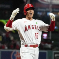 Angels designated hitter Shohei second from left) celebrates with teammates Andrew Velazquez and Mike Trout after hitting a grand slam against the Rays in Anaheim, California, on Monday. | USA TODAY / VIA REUTERS