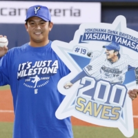 The BayStars' Yasuaki Yamasaki poses after recording his 200th save on Wednesday in Osaka. | KYODO