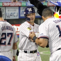 Yakult's Norichika Aoki (center) is welcomed at the dugout after his seventh-inning home run against the Tigers at Tokyo's Jingu Stadium on Tuesday. | KYODO