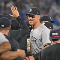 Aaron Judge (center) celebrates with his Yankees teammates after beating the Blue Jays to clinch the American League East division title in Toronto on Tuesday. | USA TODAY / VIA REUTERS