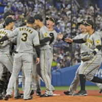 Hanshin players celebrate after beating the BayStars to advance to the finals of the Central League Climax Series in Yokohama on Monday. | KYODO