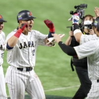 Kazuma Okamoto (center) is congratulated by Shohei Ohtani after hitting a three-run home run for Samurai Japan during the third inning of its game against Italy at Tokyo Dome on Thursday. | KYODO