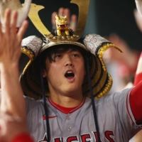 Shohei Ohtani is congratulated by his teammate after hitting a two-run home run against the Rangers in the eighth inning in Arlington, Texas, on Thursday. | KYODO